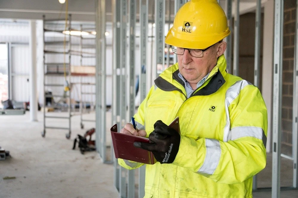 Construction safety inspector checking site compliance with regulations.